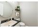 Powder bathroom with a white toilet, modern round mirror and dark granite countertop at 1516 Jae Pl, Lakeland, FL 33803