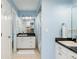 Bright blue bathroom with dual vanities, dark countertops and a shower/tub combo at 1516 Jae Pl, Lakeland, FL 33803