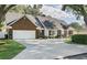 Charming exterior showcasing a well-manicured lawn, mature landscaping, and an inviting front entrance with a circular driveway at 1516 Jae Pl, Lakeland, FL 33803