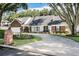 Well-maintained house with a circular driveway, lush landscaping, and mature trees at 1516 Jae Pl, Lakeland, FL 33803