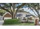 Charming one-story home featuring manicured landscaping and a mature tree canopy at 1516 Jae Pl, Lakeland, FL 33803