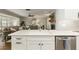 Bright kitchen showcasing white cabinets, stainless steel appliances, and an open layout to the living area at 1516 Jae Pl, Lakeland, FL 33803