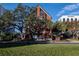 Stunning brick building with large windows and mature trees against a bright blue sky at 200 Lake Morton Dr # 100, Lakeland, FL 33801