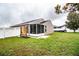 Exterior view of the home's backyard with a screened-in lanai and modern wooden screen element at 2040 Chickadee St, Bartow, FL 33830