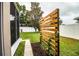 Landscaped backyard featuring a modern wooden screen element, green grass and white vinyl fence at 2040 Chickadee St, Bartow, FL 33830
