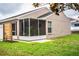 Exterior view of the home's backyard with a screened-in lanai and modern wooden screen at 2040 Chickadee St, Bartow, FL 33830