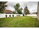 Well-maintained backyard with green lawn, white vinyl fence and perimeter flower beds at 2040 Chickadee St, Bartow, FL 33830