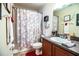Cozy bathroom featuring decorative shower curtain, dark granite vanity, and decorative wall hangings at 2040 Chickadee St, Bartow, FL 33830