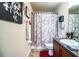 Well-lit bathroom features decorative shower curtain, dark granite vanity, and tasteful decorative wall hangings at 2040 Chickadee St, Bartow, FL 33830