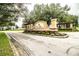 Elegant entrance to West Meadows community featuring manicured landscaping and decorative signage at 2040 Chickadee St, Bartow, FL 33830