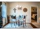 Cozy dining area showcasing a glass table, unique chairs, and view into the primary bedroom at 2040 Chickadee St, Bartow, FL 33830