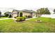 Home's front yard, featuring manicured shrubs and a lush green lawn at 2040 Chickadee St, Bartow, FL 33830