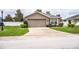 Quaint home with manicured shrubs, an attached garage, and a well-kept front lawn at 2040 Chickadee St, Bartow, FL 33830