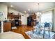 Open-concept kitchen with dark wood cabinets, appliances, adjacent dining area, and wood flooring at 2040 Chickadee St, Bartow, FL 33830