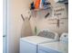 Functional laundry room featuring modern washer and dryer, storage shelves and ironing board at 2040 Chickadee St, Bartow, FL 33830