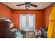 Bedroom with a glass door, lots of items, and orange walls at 2219 New Jersey Rd, Lakeland, FL 33803