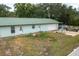 The rear exterior of the home shows a simple design with a green metal roof and a large driveway at 2219 New Jersey Rd, Lakeland, FL 33803