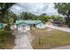 Charming home with a green roof, large yard, and concrete driveway, exuding a rustic appeal at 2219 New Jersey Rd, Lakeland, FL 33803