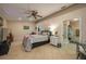 Comfortable main bedroom with en-suite bathroom access and a ceiling fan at 2219 New Jersey Rd, Lakeland, FL 33803