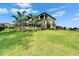 Expansive backyard featuring lush landscaping, a screened-in patio, and an elegant two-story home at 2662 Delphi Hills Ct, Lakeland, FL 33812