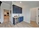 Stylish bar area with sleek navy cabinetry, sink, marble countertop, and a built-in beverage cooler at 2662 Delphi Hills Ct, Lakeland, FL 33812