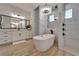 Modern bathroom featuring a soaking tub, walk-in shower, sleek black fixtures, and a stylish light fixture at 2662 Delphi Hills Ct, Lakeland, FL 33812