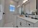 Well-lit bathroom showcases a walk-in shower, a window, and a pristine white vanity with modern fixtures at 2662 Delphi Hills Ct, Lakeland, FL 33812
