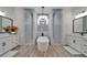 Elegant bathroom featuring a soaking tub between two walk-in showers, stylish lighting, and dual vanities at 2662 Delphi Hills Ct, Lakeland, FL 33812