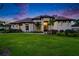 Elegant exterior showcasing a manicured lawn, tasteful landscaping, and architectural details against a twilight sky at 2662 Delphi Hills Ct, Lakeland, FL 33812