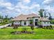 Stunning two-story home with manicured lawn, mature trees, and colorful flower beds offering great curb appeal at 2662 Delphi Hills Ct, Lakeland, FL 33812