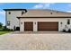 Side view of home with three-car garage and paved driveway at 2662 Delphi Hills Ct, Lakeland, FL 33812
