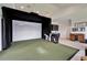 Bright room with a professional golf simulator, green turf, and large display screen for realistic gameplay at 2662 Delphi Hills Ct, Lakeland, FL 33812