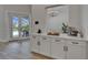Gourmet kitchen features a beverage station with white cabinetry and view of the pool through French doors at 2662 Delphi Hills Ct, Lakeland, FL 33812