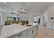 Kitchen island with white marble countertop, pendant lighting, and an open floor plan to the living room at 2662 Delphi Hills Ct, Lakeland, FL 33812