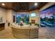 Inviting outdoor living space with a stone fireplace, comfortable seating, and a built-in wet bar area at 2662 Delphi Hills Ct, Lakeland, FL 33812