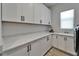 Bright laundry room with white cabinets, granite countertops, sink, and natural light at 2662 Delphi Hills Ct, Lakeland, FL 33812