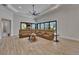 Open living room boasts a vaulted ceiling and tan sectional seating area with backyard views at 2662 Delphi Hills Ct, Lakeland, FL 33812