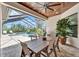 Covered outdoor dining area with a wooden table set, grill, and views of the screened-in pool at 2662 Delphi Hills Ct, Lakeland, FL 33812