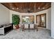 Outdoor dining area featuring a ceiling fan, grill, and wooden table set on a stone-brick patio at 2662 Delphi Hills Ct, Lakeland, FL 33812