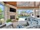 Covered patio with stone fireplace, outdoor seating, and a view of the sparkling pool at 2662 Delphi Hills Ct, Lakeland, FL 33812