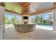 Screened-in patio with stone fireplace, outdoor seating, and a view of the sparkling pool at 2662 Delphi Hills Ct, Lakeland, FL 33812