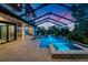 Beautiful pool with spa and waterfall features, surrounded by lush landscaping and an expansive patio at 2662 Delphi Hills Ct, Lakeland, FL 33812