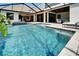 Outdoor living area with a pool, spa, covered seating, and dining areas within a screened enclosure at 2662 Delphi Hills Ct, Lakeland, FL 33812