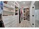 Spacious walk-in closet featuring built-in shelving, drawers, shoe racks, and a light wood-look tile floor at 2662 Delphi Hills Ct, Lakeland, FL 33812