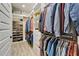 Large walk-in closet with built-in shelving and hanging rods for clothing and shoes at 2662 Delphi Hills Ct, Lakeland, FL 33812