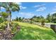 Beautifully landscaped yard showcasing a well-maintained lawn, mature trees, and a charming home in the distance at 2662 Delphi Hills Ct, Lakeland, FL 33812