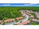 An aerial view of residential townhouses with lush trees and greenery surrounding the attractive units at 2683 Corvette Ln, Kissimmee, FL 34746