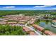 Aerial view showcasing a well-maintained community with lush landscaping, a pond, and neat rows of townhomes at 2683 Corvette Ln, Kissimmee, FL 34746