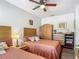 Bedroom with two beds, ceiling fan, wood flooring, and a rustic armoire at 2683 Corvette Ln, Kissimmee, FL 34746