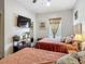 Bedroom featuring two beds, wood floors, ceiling fan, and natural light from the window at 2683 Corvette Ln, Kissimmee, FL 34746